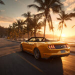 Желтый кабриолет Ford Mustang едет по живописной трассе вдоль моря в Паттайе на закате